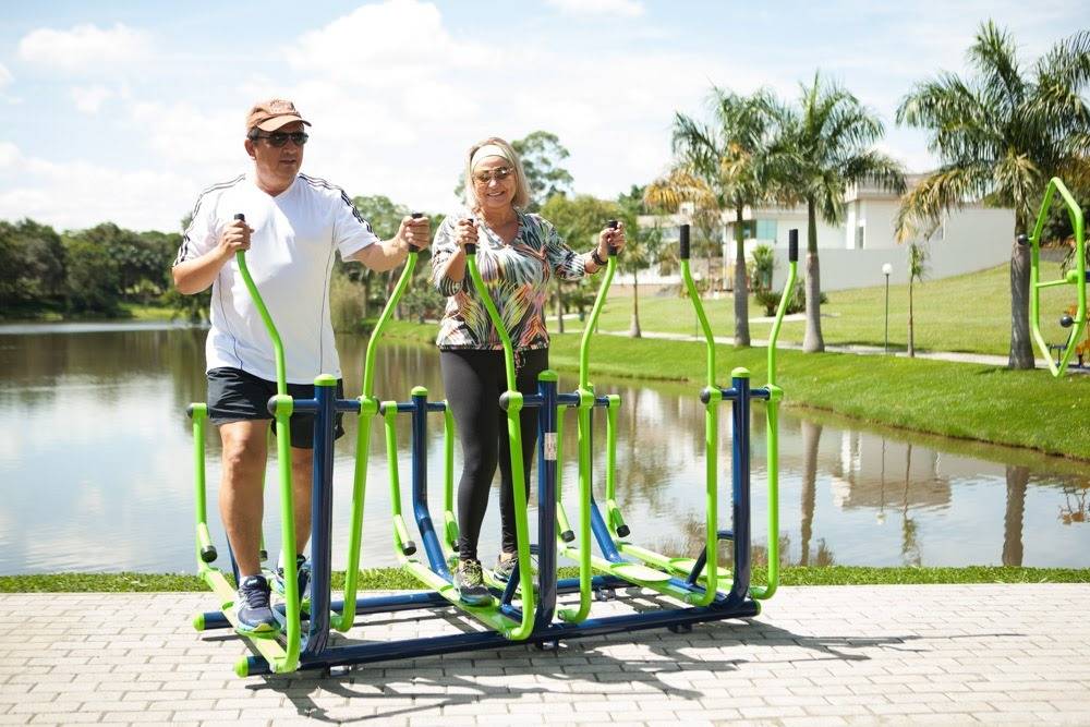 Group of people using outdoor fitness equipment in a park